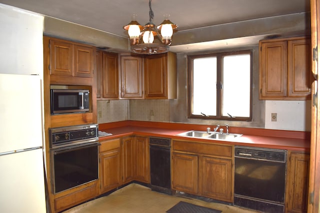 kitchen with brown cabinetry, light floors, an inviting chandelier, black appliances, and a sink