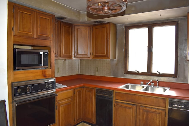 kitchen featuring black appliances, brown cabinets, and a sink