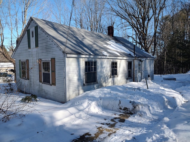 view of front facade with metal roof and a chimney