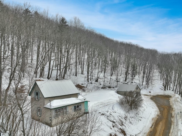 snowy aerial view with a wooded view