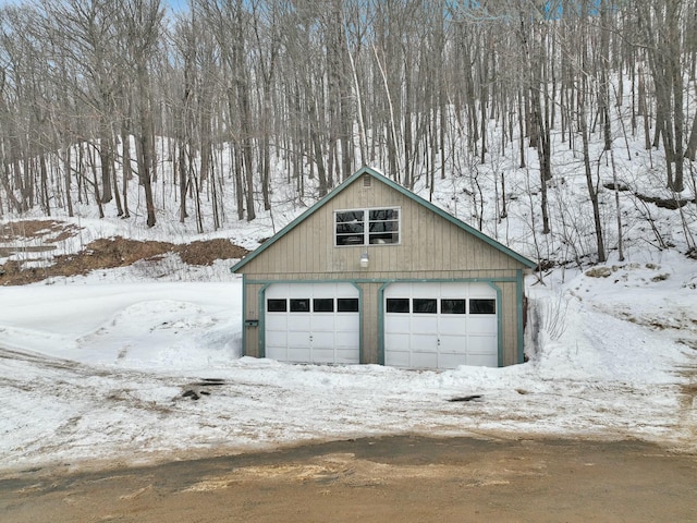 snow covered garage featuring a garage