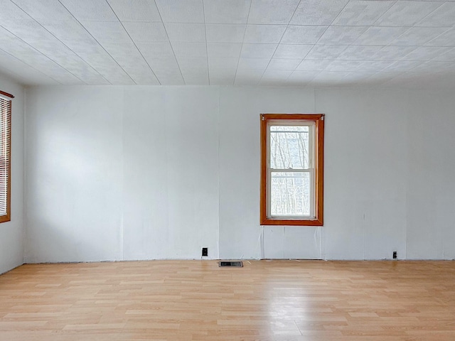 unfurnished room featuring visible vents and wood finished floors