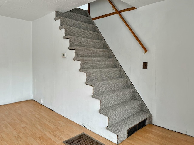 staircase featuring visible vents and wood finished floors