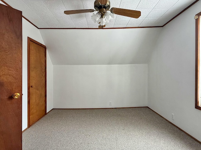 additional living space with lofted ceiling, carpet, baseboards, and ceiling fan