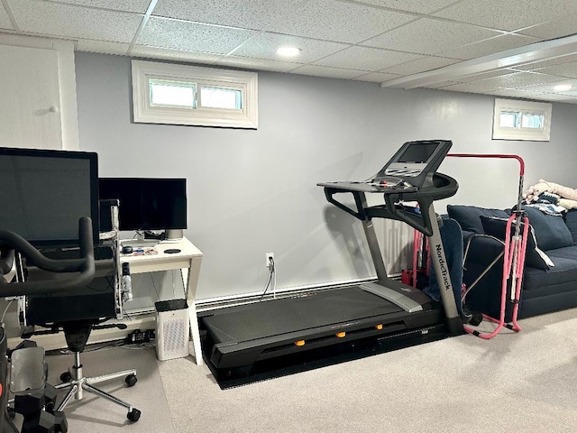 exercise room featuring carpet floors and a paneled ceiling