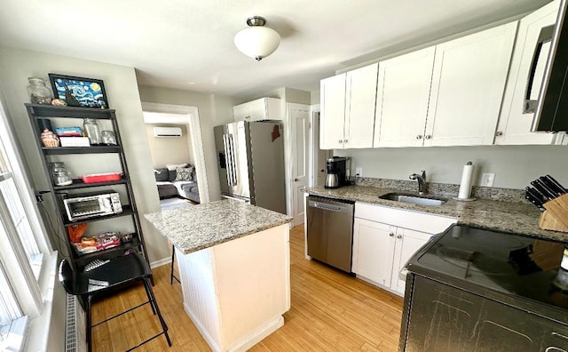 kitchen featuring electric range, light wood-style flooring, refrigerator, stainless steel dishwasher, and a sink