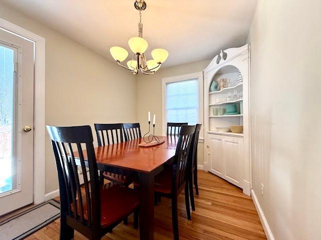 dining room with a chandelier, light wood-type flooring, and a healthy amount of sunlight