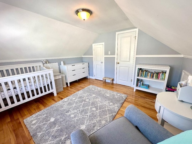 bedroom featuring lofted ceiling and wood finished floors