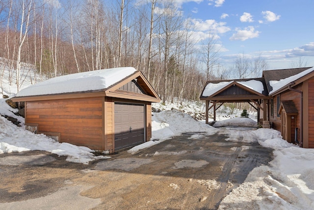 snow covered garage with a detached garage