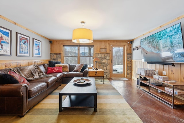 living room with a wainscoted wall, ornamental molding, and wooden walls