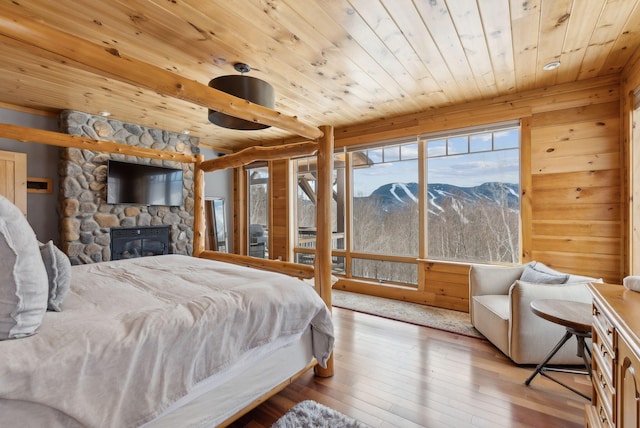 bedroom featuring access to exterior, wood ceiling, a fireplace, and hardwood / wood-style flooring