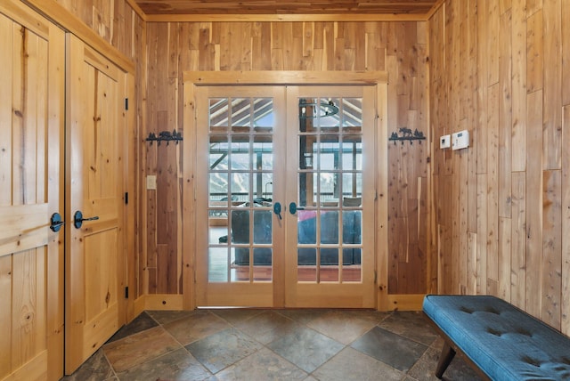 doorway to outside featuring french doors, wood walls, and stone tile flooring