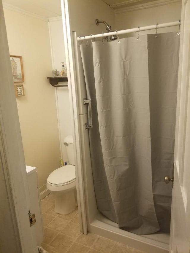 bathroom with tile patterned flooring, toilet, vanity, ornamental molding, and a shower stall