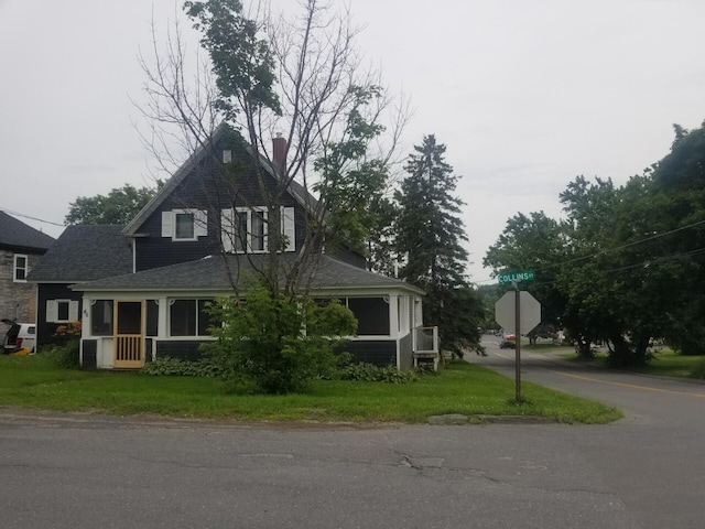 view of front of home featuring a sunroom and a front yard