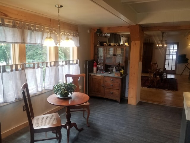 dining room with dark wood-style floors, baseboards, and an inviting chandelier