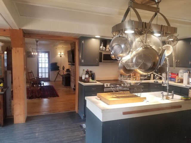 46 Collins St, Caribou, ME 04736 - kitchen with dark wood-style floors, light countertops, stainless steel microwave, and a sink
