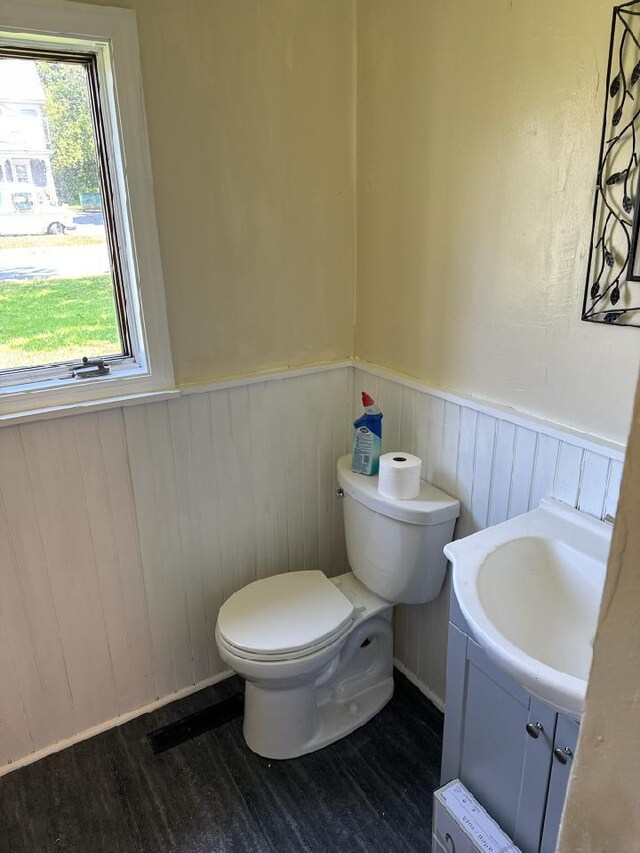 46 Collins St, Caribou, ME 04736 - half bathroom featuring a wainscoted wall, toilet, and wood finished floors