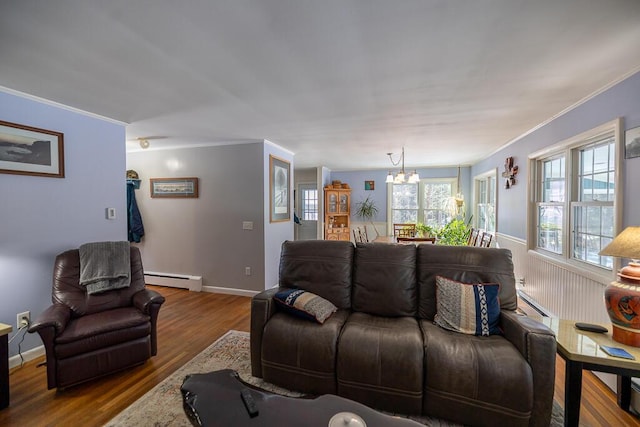 living area featuring a baseboard heating unit, crown molding, and wood finished floors