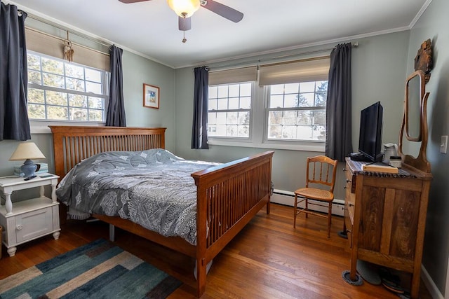 bedroom featuring ceiling fan, baseboard heating, wood finished floors, and crown molding