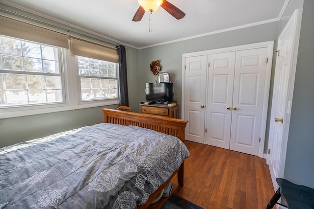 bedroom with a closet, a ceiling fan, dark wood finished floors, and crown molding