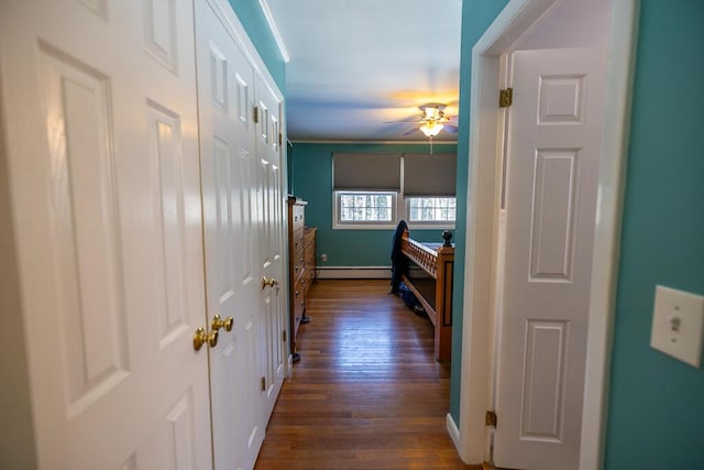 hallway featuring a baseboard radiator, baseboards, and dark wood-style flooring