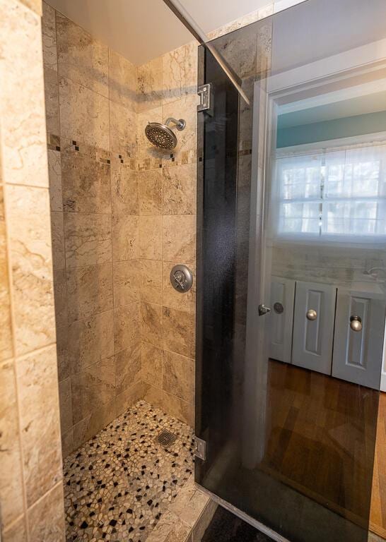 full bathroom with a stall shower and wood finished floors