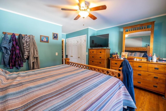 bedroom with a ceiling fan, a closet, ornamental molding, and wood finished floors