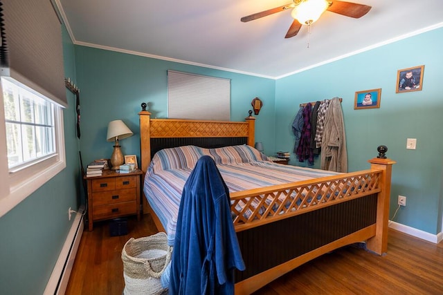 bedroom with baseboards, crown molding, a baseboard heating unit, and wood finished floors