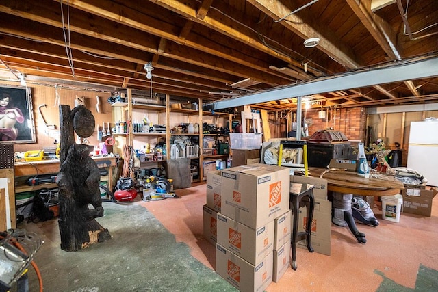 unfinished basement featuring freestanding refrigerator