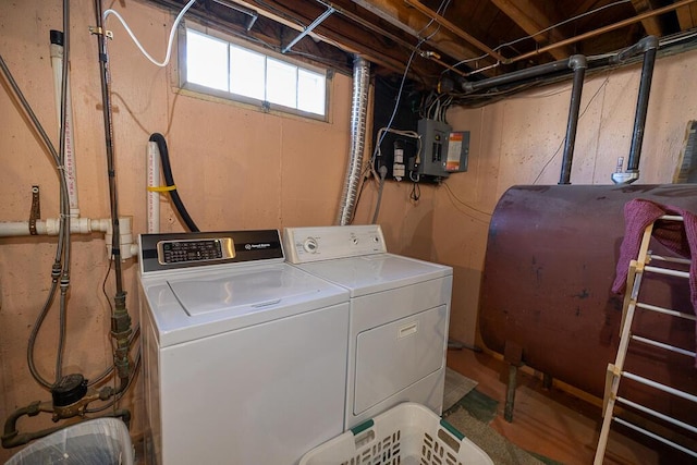 clothes washing area featuring laundry area, electric panel, independent washer and dryer, and heating fuel