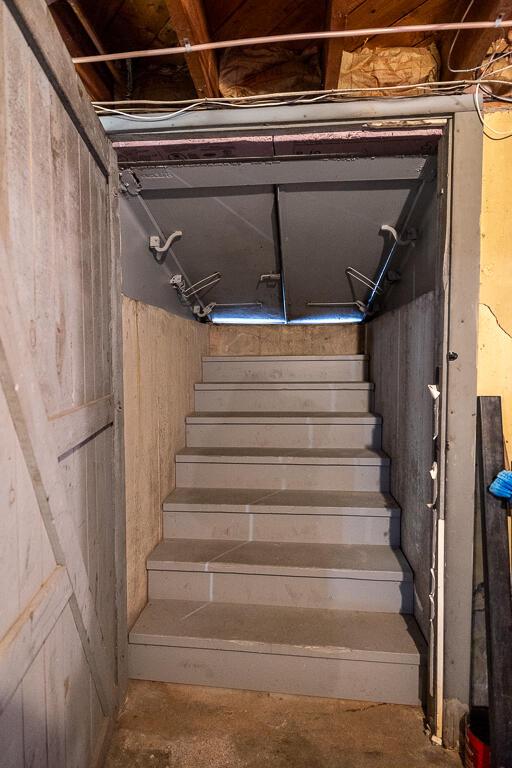 stairway with unfinished concrete flooring