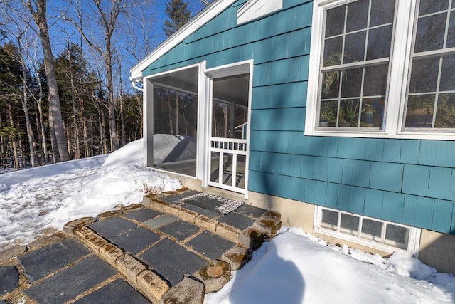 snow covered property featuring a sunroom