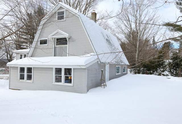 colonial inspired home with a chimney and a gambrel roof