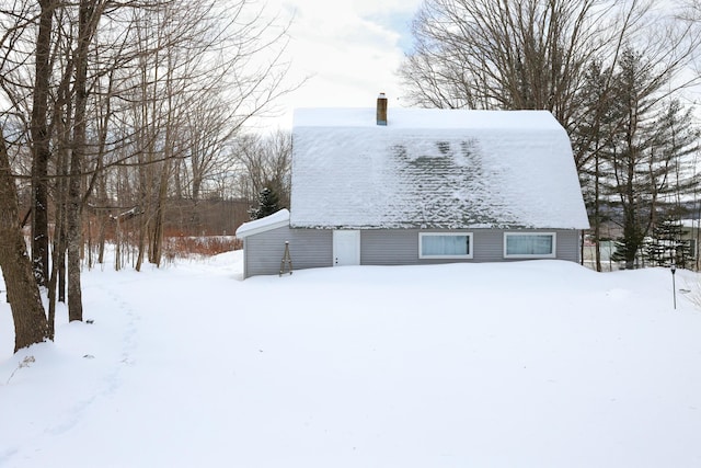 snow covered property featuring a chimney