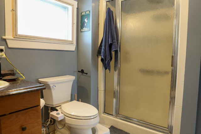 full bathroom featuring a stall shower, vanity, and toilet