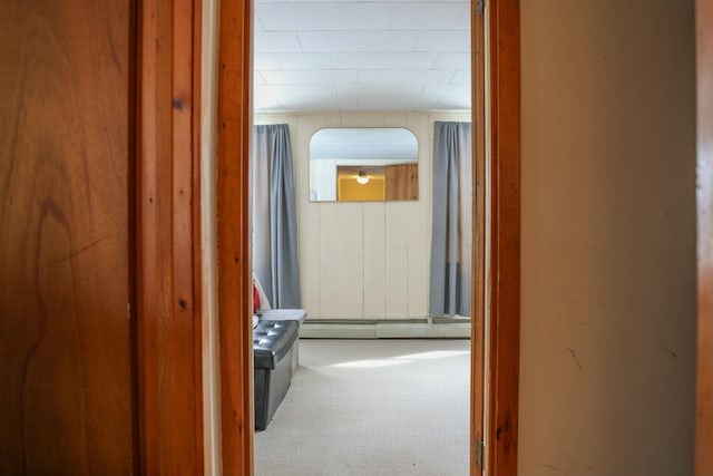 hall featuring a baseboard heating unit and carpet