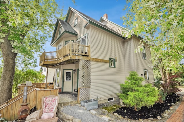 exterior space featuring a chimney and a wooden deck