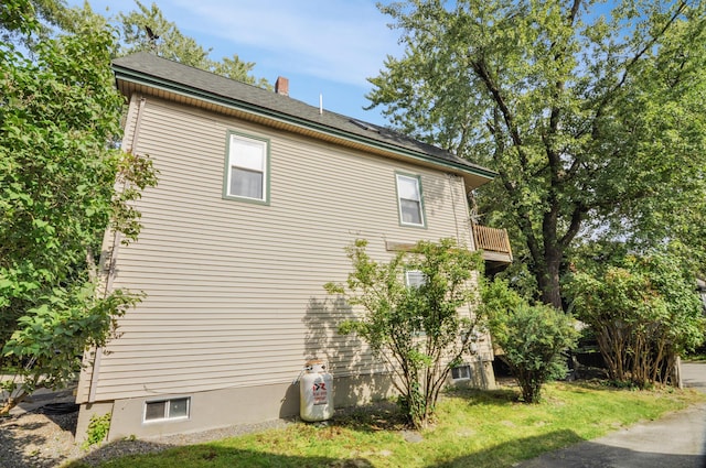 view of side of property with a lawn and a chimney