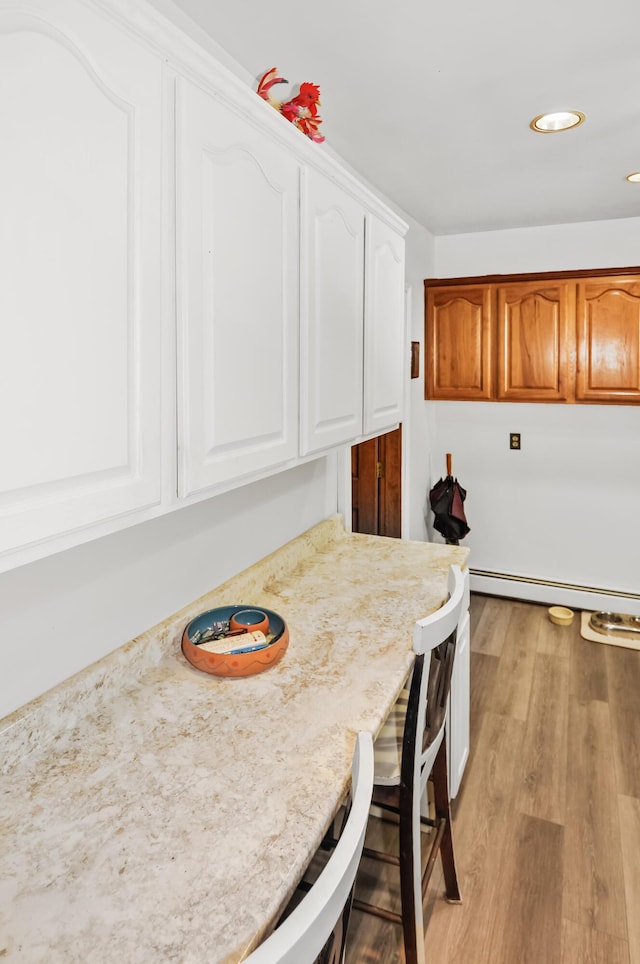 dining area with a baseboard radiator, light wood-style flooring, and recessed lighting