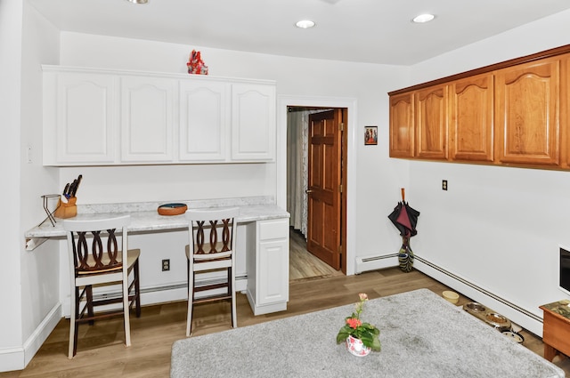 office space with recessed lighting, a baseboard heating unit, baseboards, baseboard heating, and light wood finished floors