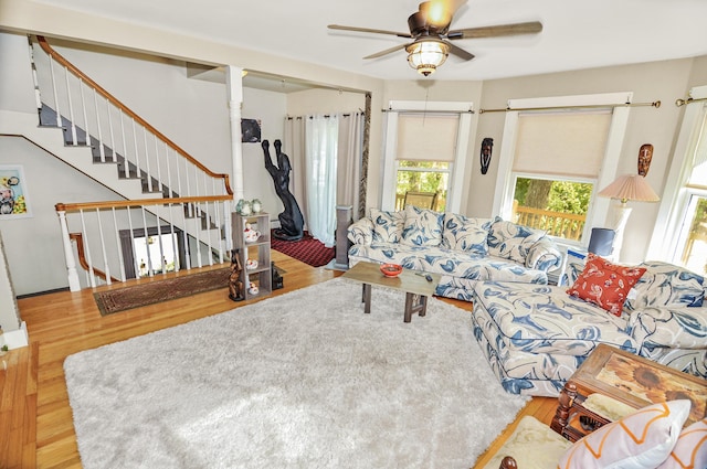 living room featuring stairs, a ceiling fan, and wood finished floors