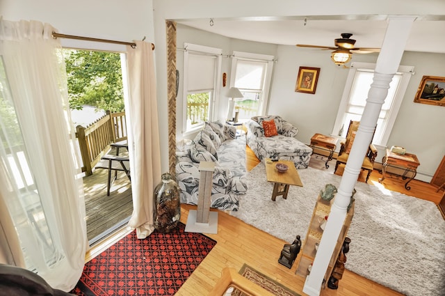 living room with a ceiling fan, ornate columns, and wood finished floors