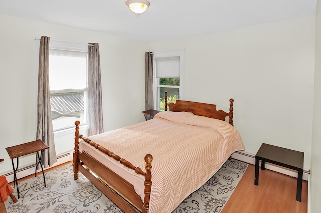 bedroom featuring light wood-type flooring and a baseboard radiator