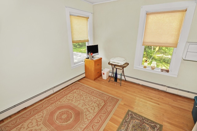 office with a baseboard heating unit, a baseboard radiator, plenty of natural light, and wood finished floors