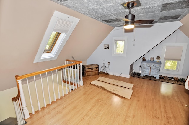 bonus room with a skylight, plenty of natural light, and wood finished floors