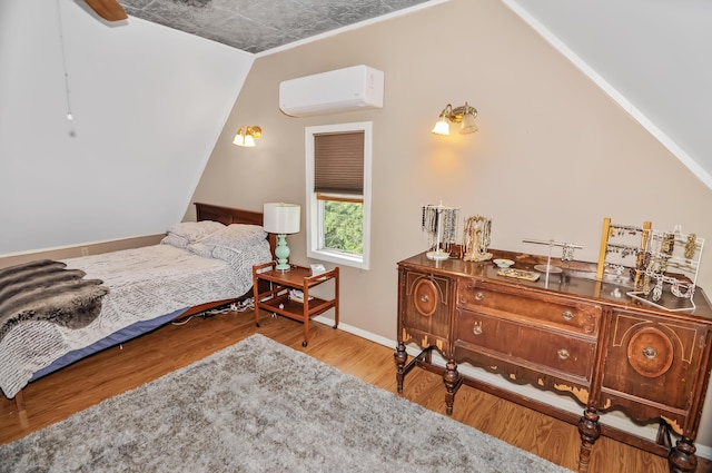 bedroom featuring baseboards, vaulted ceiling, wood finished floors, and a wall mounted AC