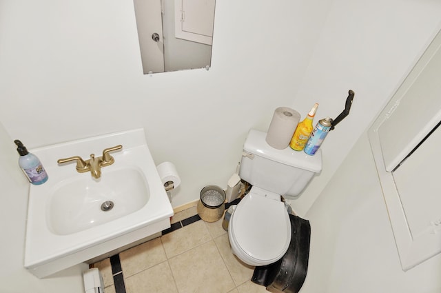 half bath featuring a sink, toilet, and tile patterned floors