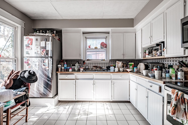 kitchen featuring a wealth of natural light, backsplash, stainless steel appliances, and a sink