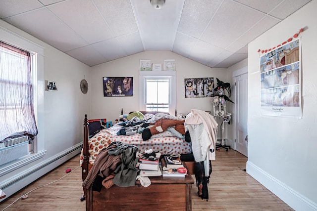 bedroom featuring baseboards, baseboard heating, vaulted ceiling, and light wood finished floors