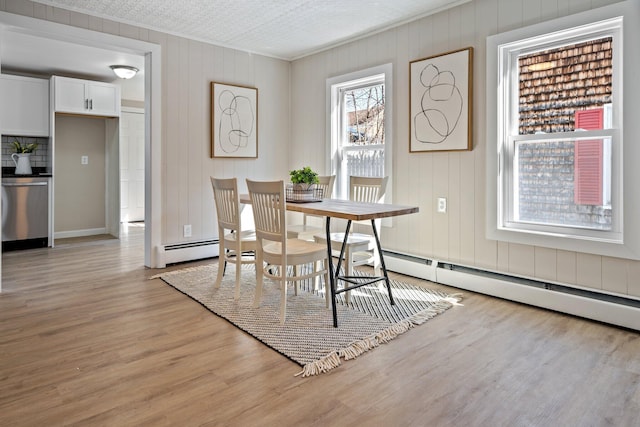 dining room featuring baseboard heating and light wood-style flooring